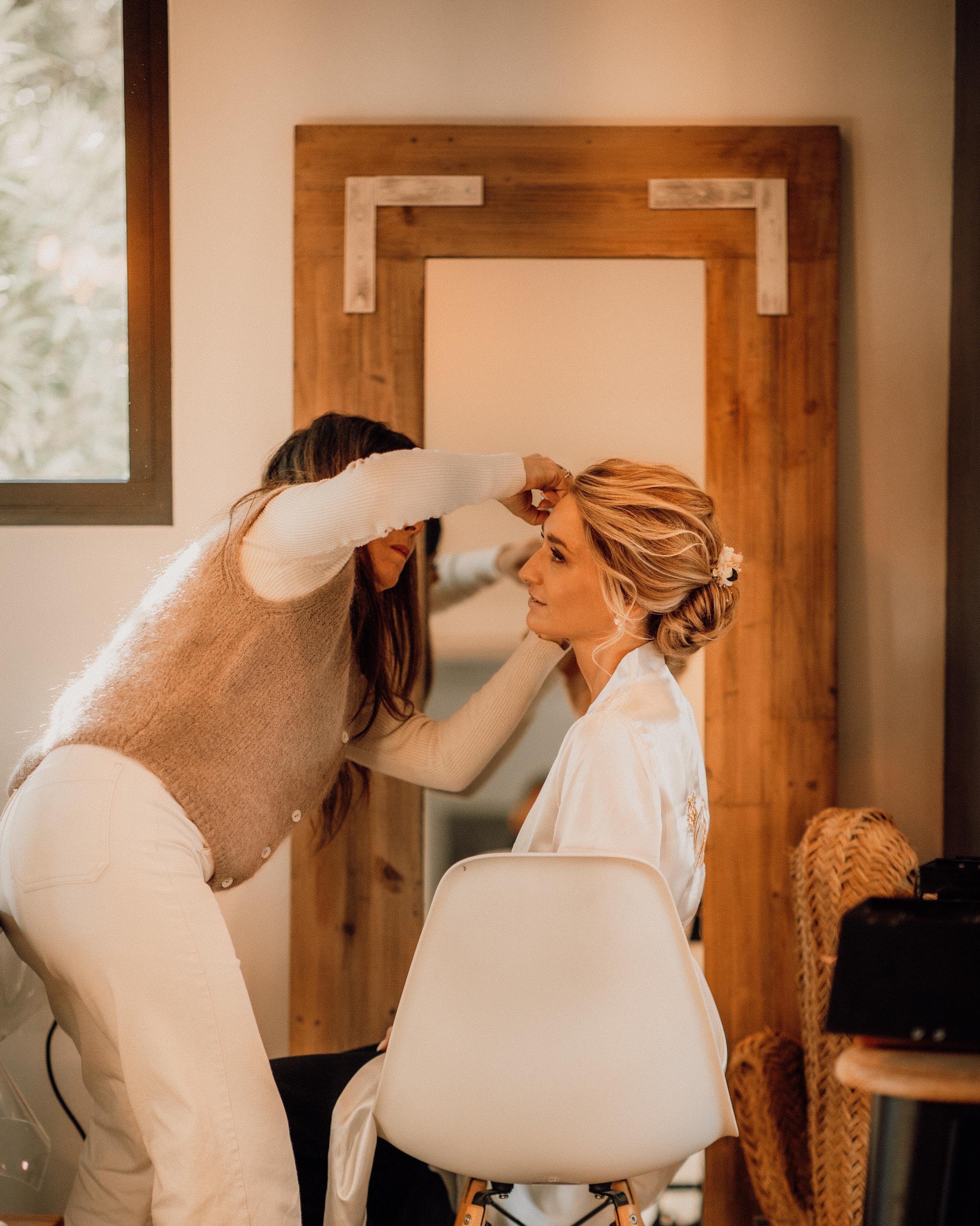 Aurore coiffant une mariée devant un miroir