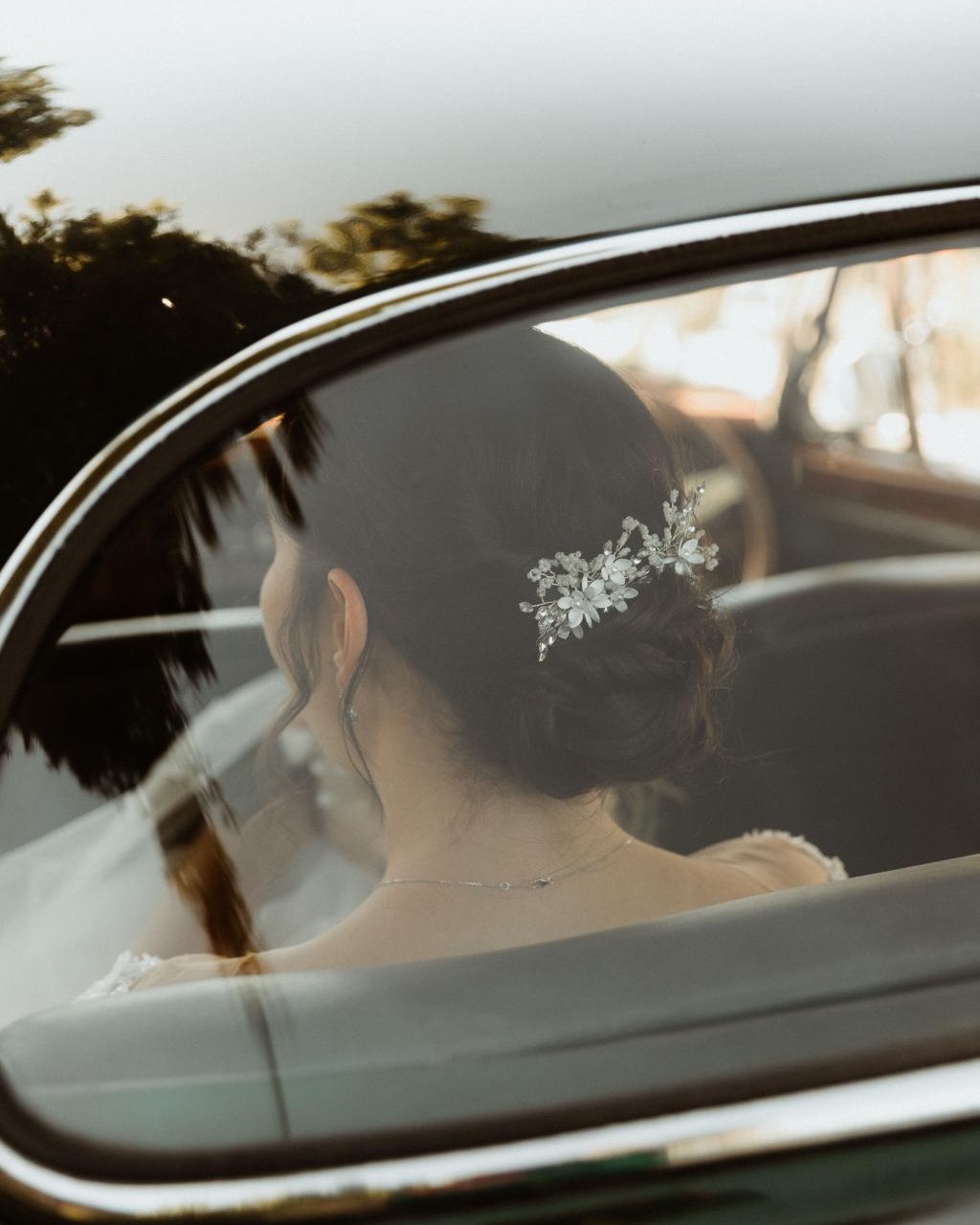 Détail d'un chignon de mariée avec bijou floral, dans une voiture