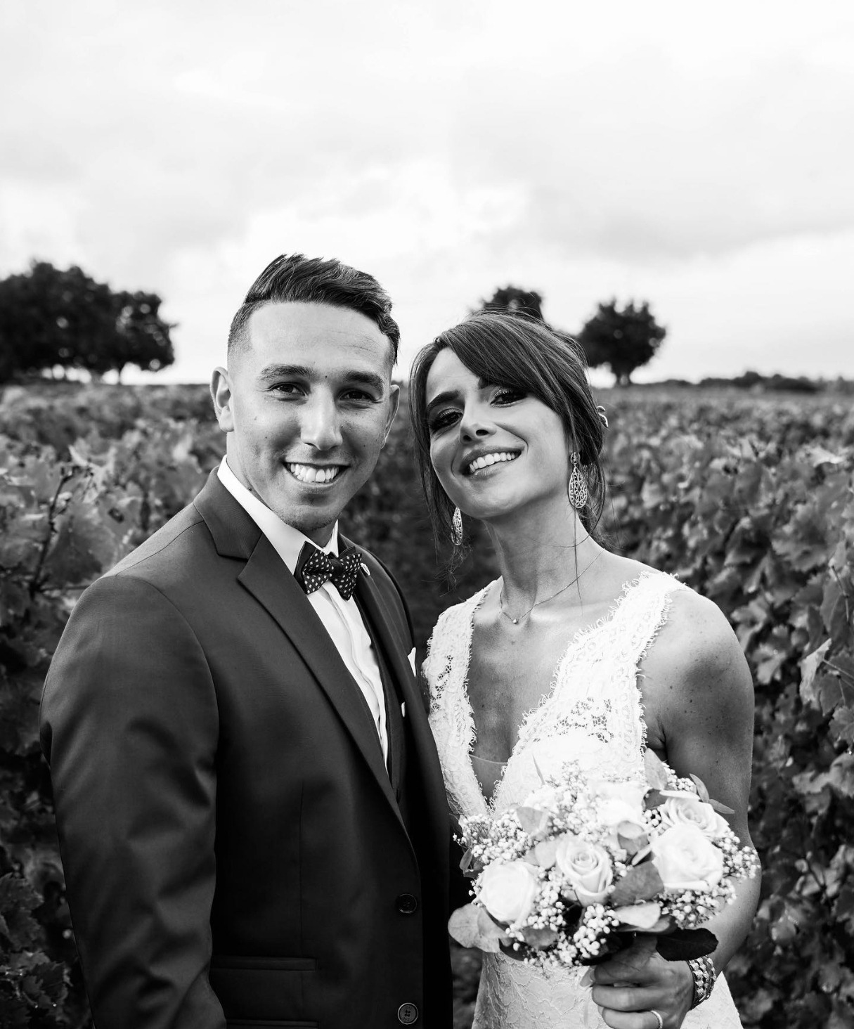 Mariée et marié souriants dans les vignes, noir et blanc